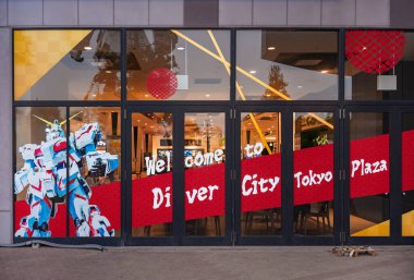 Tokyo, odaiba - 22 Mayıs 2025: DiverCity Tokyo Plaza 'nın girişi Japonya' nın meka kültürü ve pop etkisini vurgulayan büyük UNICORN GUNDAM çıkartmalı bir cam cephe içeriyor.