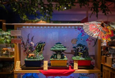 tokyo, odaiba - may 22 2025: Japanese art sculptures depicting bonsai dioramas featuring iconic scenes from Spirited Away, My Neighbor Totoro, and Princess Mononoke displayed at Ghibli store entrance.