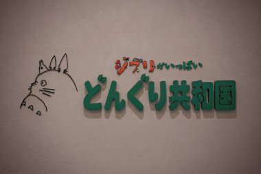 Tokyo, odaiba - 22 Mayıs 2025: Japon Totoro temalı logosu, Ghibli 'nin Hayao Miyazaki animasyon yönetmeni tarafından yaratılan film çalışmaları ve şekerlemelerine adanmış Donguri Cumhuriyet mağazasının duvarında sergilendi..