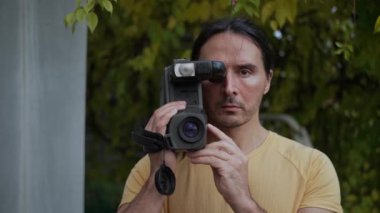 Genç bir adam eski bir retro kamerada video çekiyor. 80 'ler, ağır çekim. Yüksek kalite 4k görüntü