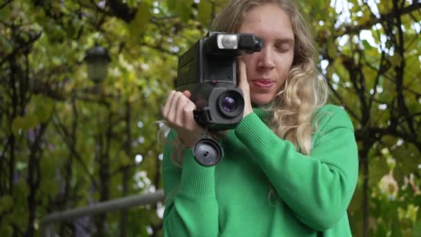 屋外に立っている間 古いヴィンテージカメラを使用して1人の若い白いハンサムな女性のクローズアップビュー 高品質4K映像 スローモーション — ストック動画