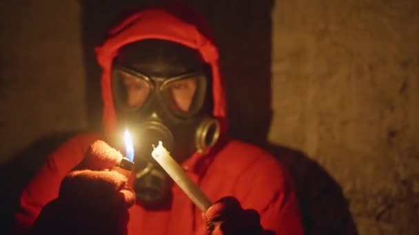 乌克兰战争 一个戴着防毒面具的年轻人躲在防空洞里躲避火箭袭击 没有电 他点了一支蜡烛 4K视频 — 图库视频影像