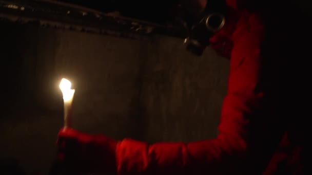 一个戴防毒面具的男人躲在防空洞里 一个人在防空洞里用石蜡蜡烛查看食物供应 停电了 高质量的4K镜头 — 图库视频影像