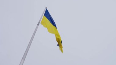 Bulutlu gökyüzüne karşı Ukrayna bayrağı. Ukrayna 'nın sarı-mavi bayrağı dalgalanıyor. Ukrayna Ulusal Sembolü. Ağır çekim. Yüksek kalite 4k görüntü