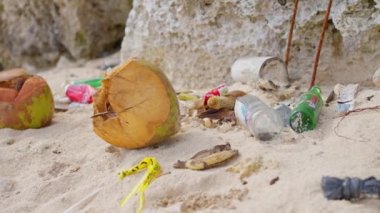 Turistlerin Sahilde, Kumda, Yavaş Hareket 'te bıraktığı çöpler. Okyanus kıyısındaki ekoloji, plastik şişeler ve alüminyum atıklar, Çevresel Enkaz Kirliliği. Yüksek kalite 4k görüntü