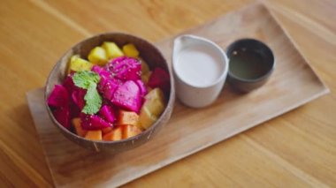 Yakın plan, Meyve Salatası, Mango, Papaya, Ejderha meyvesi, Tahta bir tabakta, Bali Kafe 'de, Tahta bir tepside, Yavaş Hareket. Yüksek kalite 4k görüntü
