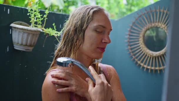 夏天的心情在热带花园淋浴间与一个迷人的女人 一滴水滴在她的皮肤上轻轻流淌 一个可爱的微笑 慢动作4K — 图库视频影像