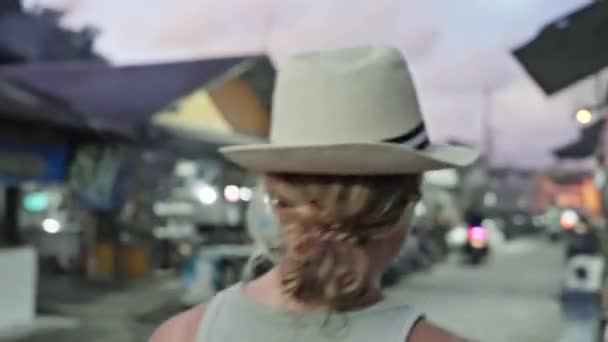 灰色のショートパンツを着た大人の女の子 トップとストローの帽子は 夕方に伝統的なアジア市場を歩く 4Kビデオ — ストック動画