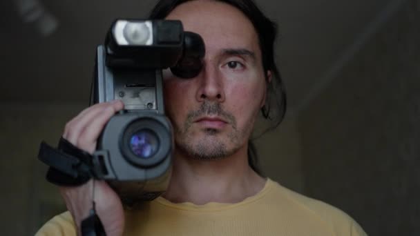 古いビデオカメラを持つ男の肖像 レトロなビデオカメラの遅い動きを持つハンサムなカメラマン 高品質4K映像 — ストック動画