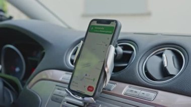 4K kullanan bir adamla arabada GPS navigasyonu. Seyrüsefer ekranına yaklaş, takip edilecek yolu göster. Akıllı telefon navigasyon cihazı. Google Maps. Akıllı telefondaki GPS navigasyon haritasını kapat