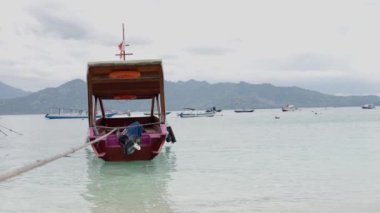 Gili Adası Endonezya - Şubat 2023: Endonezya bayraklı bir ahşap gül gemisi çatıda dalgalanmakta ve okyanusta yüzmektedir. Ağır çekim. Yüksek kalite 4k görüntü