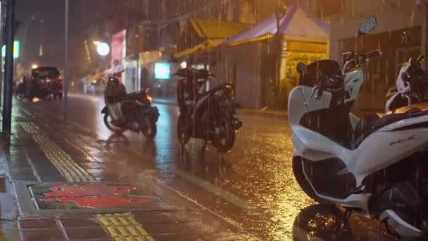 雨の夜 雨の中のバリのナイトストリート ウェットスクーターは ランタンが点灯する通りに立っています 夜の雨の中 街の光が街を照らしています 高品質で — ストック動画