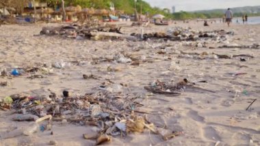 Tek kullanımlık plastik torbalar, metal ve plastik şişeler, plajdaki piknikten sonra turistlerin bıraktığı şeyler. Ağır çekim. 4K. 