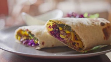 Sebze, mısır, lahanaya sarılmış pide. Yanında avokado bazlı yeşil soslu bir fincan tabağı var. Shawarma. Ağır çekim. Yüksek kalite 4k görüntü