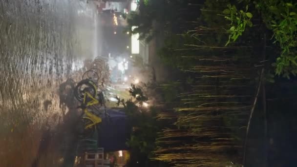 夜晚的雨 大雨倾盆地把自行车停在晚上 黄色的自行车站在街上的雨中 垂直的观点 高质量的4K镜头 — 图库视频影像