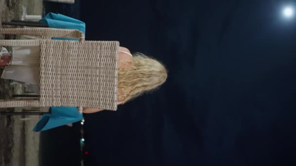 Μια Γυναίκα Κάθεται Μια Καρέκλα Ένα Τραπέζι Δίπλα Στη Θάλασσα — Αρχείο Βίντεο