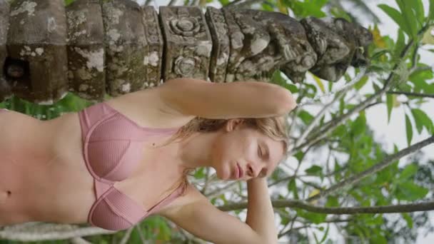 性感的卷曲的女孩站在院子里夏季的淋浴间里 一个穿着粉色泳衣的大女性乳房的特写 身体呈阳性 慢动作垂直方向 高质量的4K镜头 — 图库视频影像