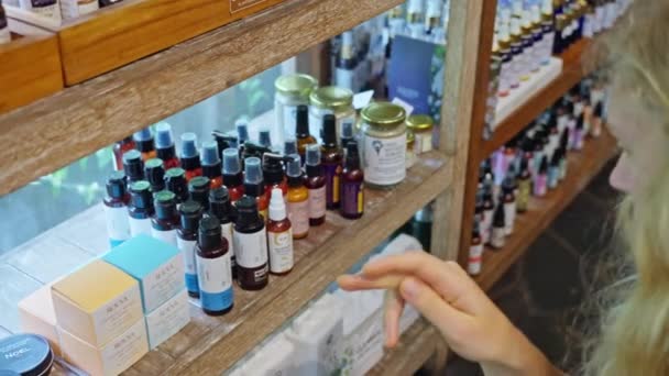 Een Vrouw Een Eco Winkel Kiest Aromatische Oliën Natuurlijke Cosmetica — Stockvideo