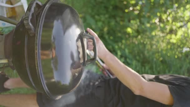 Izgarada Yemek Pişiren Çayırda Izgaranın Kapağını Kapatan Bir Adam Açık — Stok video