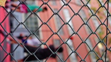 Sonbahar günü, Paris caddesinde basketbol oynayan çok ırklı adamlar, arka plan bulanıklaşmıştı. Bir basketbol oyuncusu topu sepete atıyor. Güzel bokeh, dikey manzara. Ağır çekim. 4k