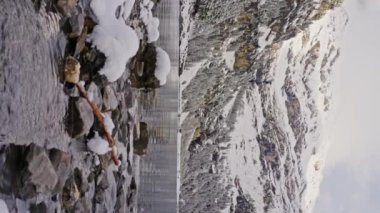 Oeschinensee karlı dağlar ve kayalarla çevrili, İsviçre 'de güzel bir göl. Göldeki dağların ayna yansıması. Dikey video. Yüksek kalite 4k görüntü
