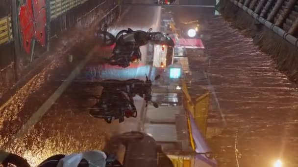 雨の夜 雨の中のバリのナイトストリート ウェットスクーターは ランタンが点灯する通りに立っています 夜の雨の中 街の光が街を照らしています 垂直オリエンテーション — ストック動画
