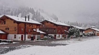 İsviçre dağlarında küçük bir köyde köy merkezi. Kar fırtınası her şeyi karla kapladı. Eski evler ve kulübeler. Süper ağır çekim. Yüksek kalite 4k görüntü