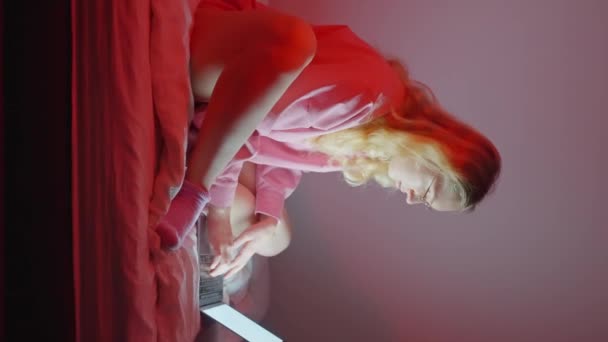 셔츠와 안경을 소녀는 노트북에 집중적으로 속에서 침대에 램프는 비디오 고품질 — 비디오