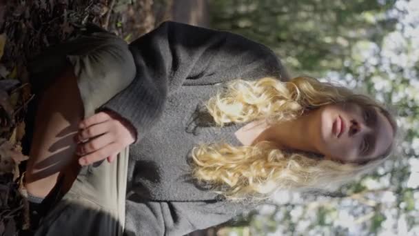 Девочка Блондинка Сидит Лесу Окружении Пышных Зеленых Растений Игрушечных Деревьев — стоковое видео