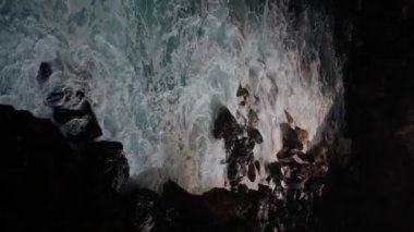 Kayalık deniz şekilleriyle çevrili okyanus karanlıkta eşsiz bir doğal manzara yaratır. Okyanus dalgaları kayalara çarpar. Gece Tenerife. 4k