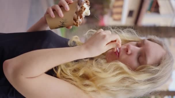 一个奇怪的手势是 一个女人用她的手和勺子细腻地吃着在华夫饼筒里的冰淇淋 她的拇指和手指在下巴附近同时工作 慢动作垂直的观点 高质量4K — 图库视频影像