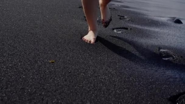 Kobieta Nogi Zbliżenie Spacery Boso Czarnej Piaszczystej Plaży Widok Tyłu — Wideo stockowe