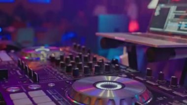 Canlı bir kulüp ortamında bir DJ 'in mikser, kumanda ve pikapta dönen şarkılarının büyüleyici görüntüleri. CDCli ekipmanlara yakın çekim enerjik ve canlı bir atmosfer yaratır.