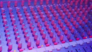 DJ kumandasında ya da ses panosunda düğmeler. Kayıt stüdyosunda çalışma süreci. Parlak anahtarlı bulanık arkaplan. Gece partisinde müzisyen. Kapatın. Yüksek kalite 4k görüntü