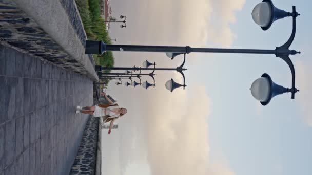 Eine Frau Läuft Unter Wolkenverhangenem Himmel Fröhlich Über Den Bürgersteig — Stockvideo