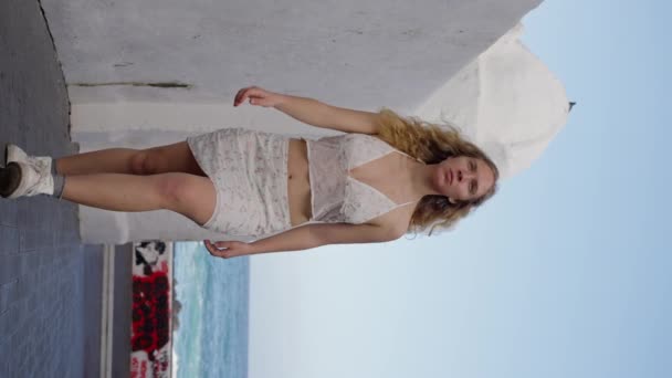 Eine Frau Weißem Kleid Geht Neben Einem Weißen Gebäude Meer — Stockvideo