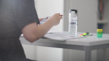 Bir kişi masada elinde şişe ve fosforlu kalemle çalışırken görülüyor. Eğitimle ilgili konular için ideal