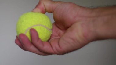 Sarı bir tenis topunu sıkan bir el stresi yönetmek ya da egzersiz yoluyla el kaslarını güçlendirmek için idealdir. Yavaş çekim 4k