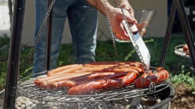 Kapalı çekimde, açık havada lezzetli sosisler pişirirken çekilmiş bir resim. Yaz barbekü etkinliği için ideal. Yavaş çekim 4k
