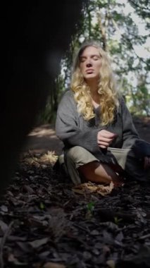 Büyüleyici bir ormanda oturan sakin bir figür doğanın özünü sergiliyor güzellik ve sükuneti.