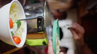 Olgun vişneli domatesler ve aromatik fesleğenli taze salatanın tadını çıkarın. Dikey video