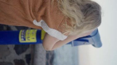 Parlak ve parçalı bulutlu bir günde manzaranın tadını çıkarmak için madeni parayla çalışan dürbünle bakan bir kadın. Yavaş çekim