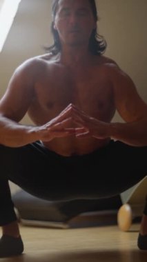 Sakin bir iç mekanda yoga yapan, esneklik ve güç gösteren odaklanmış bir birey. Dikey video