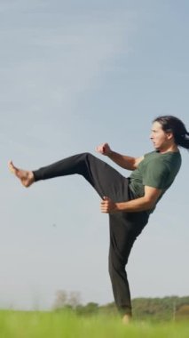 Huzurlu ve yemyeşil bir arazide barışa ilham veren bir adam dövüş sanatları icra ediyor. Adam tekmeler, ağır çekim.