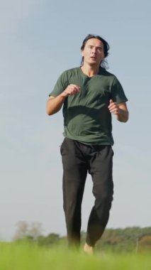 Tekvando ustası ağır çekimde tekme atıyor. Bir figür açık alanda büyüleyici bir poz verir, canlılığı somutlaştırır ve doğayla derin bir bağ kurar.