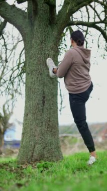 Bir insan, bacağını sağlam bir ağaca dayayıp, spor yapmayı teşvik ederken, aynı zamanda doğayla derin bir bağ kuruyor.