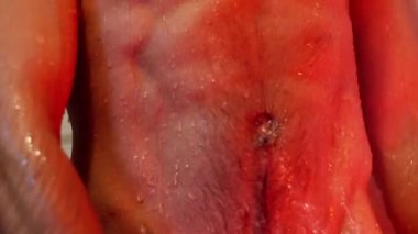 Duşun altında poz veren, etkileyici fiziğini ve su damlacıklarını sergileyen kendine güvenen bir adamı kapatın. Yavaş çekim