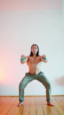 Kendini adamış bir fitness meraklısı güzel minimalist bir ortamda ustalıkla dinamik bir duruş sergiler.