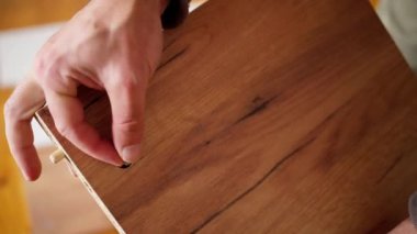 Bir zanaatkar ustalıkla vidayı düzgün, tahtadan bir tahtaya yerleştirir ve gerçek bir işçilik sergiler.