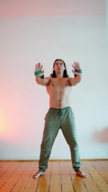 Kendini adamış bir fitness meraklısı güzel minimalist bir ortamda ustalıkla dinamik bir duruş sergiler.